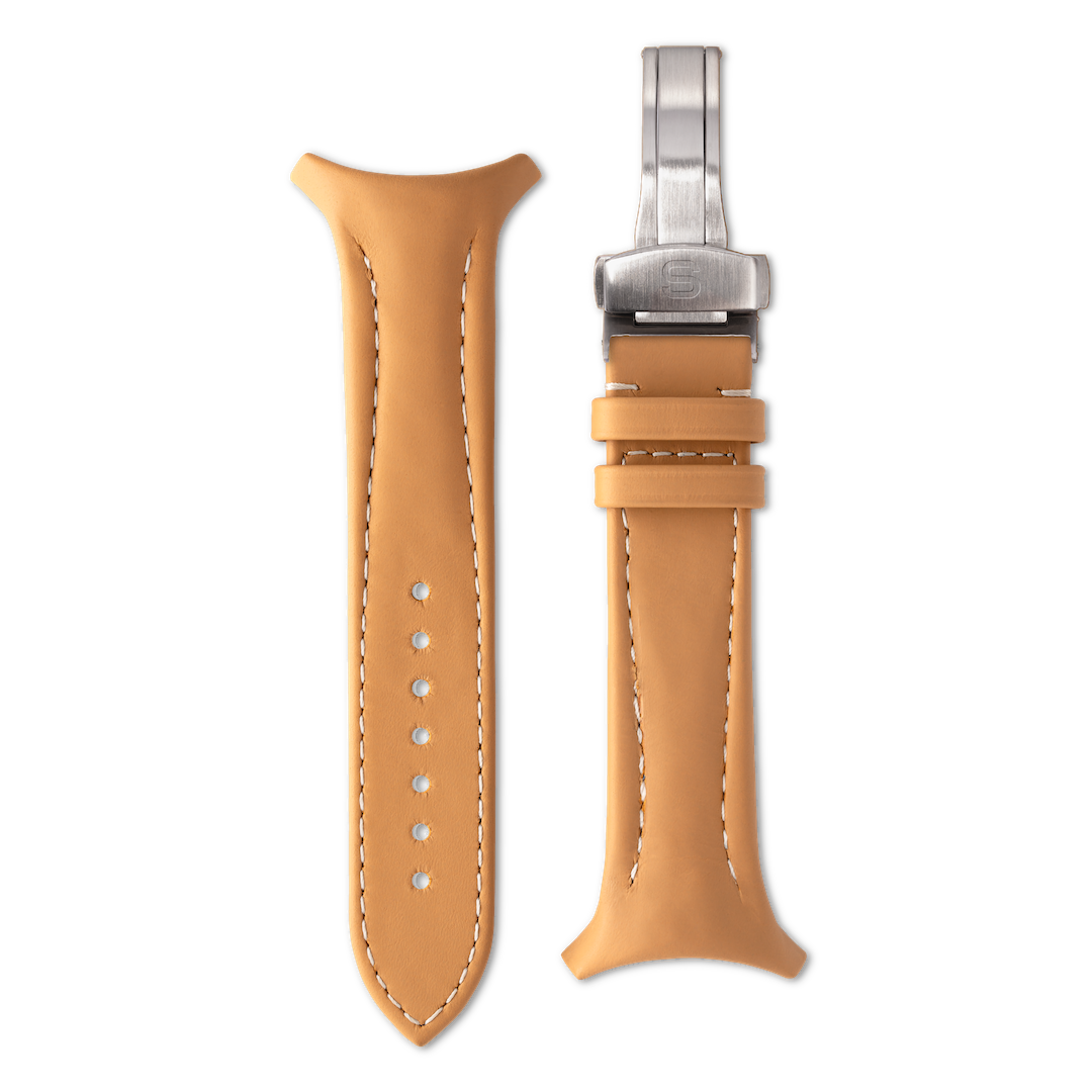 Tan leather watch strap with silver clasp on a white background