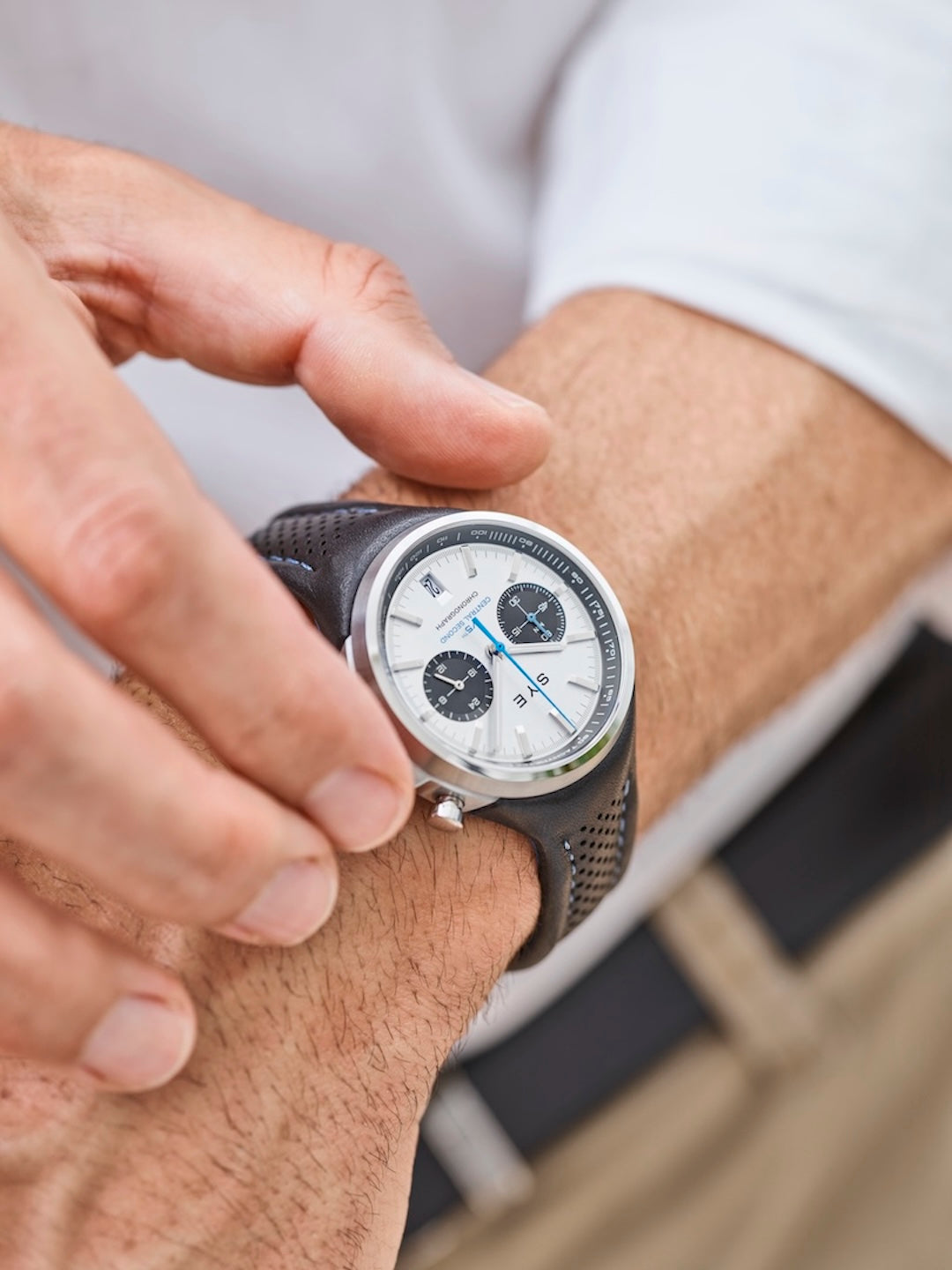 Person adjusting a watch on their wrist with a blurred background