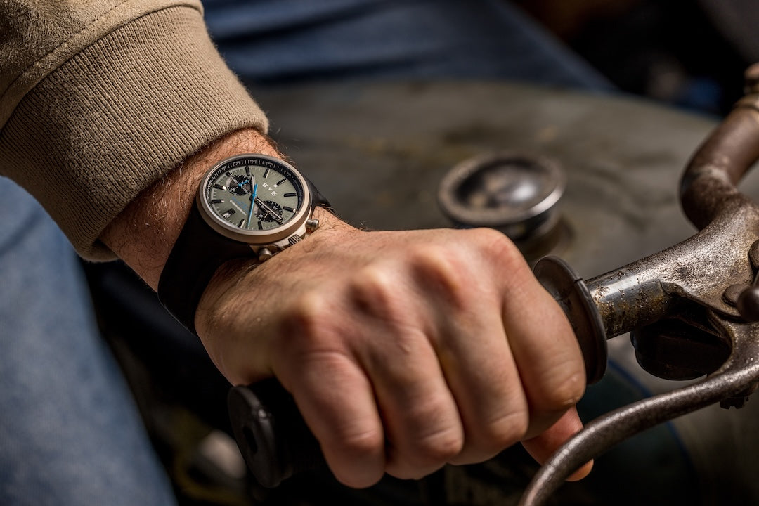 Hand wearing a watch on a vintage-style vehicle steering wheel