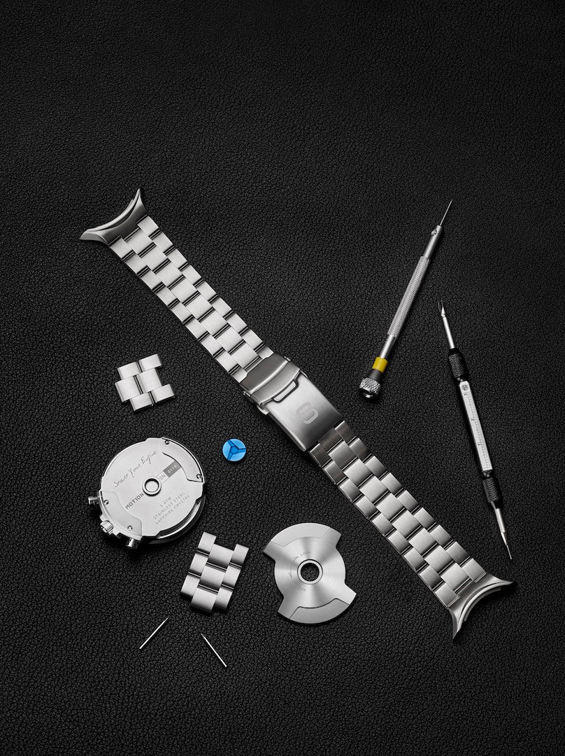Watch strap assembly with tools on a black background