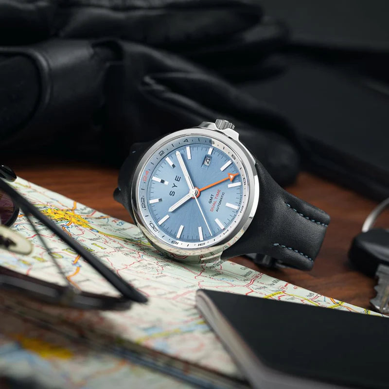 Watch with a blue face on a map and leather surface