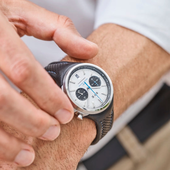 Person adjusting a watch on their wrist with a blurred background