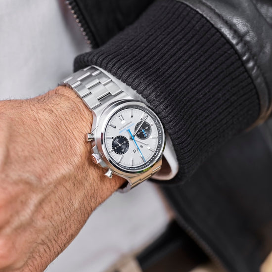 Silver wristwatch on a person's wrist with a blurred background