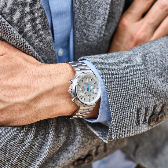 Person wearing a silver watch with a gray blazer and blue shirt