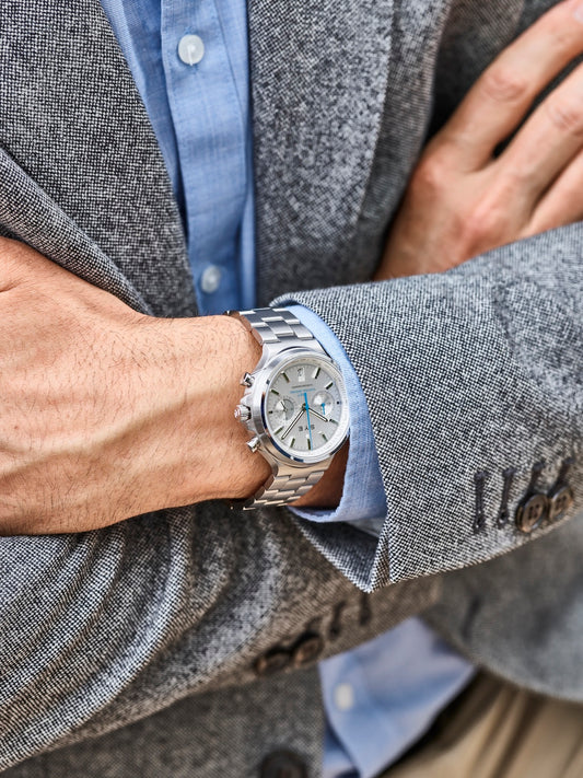 Person wearing a silver watch with a gray blazer and blue shirt
