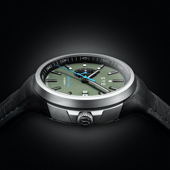 Watch with a green dial and black strap on a dark background