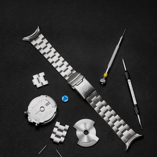 Watch strap assembly with tools on a black background