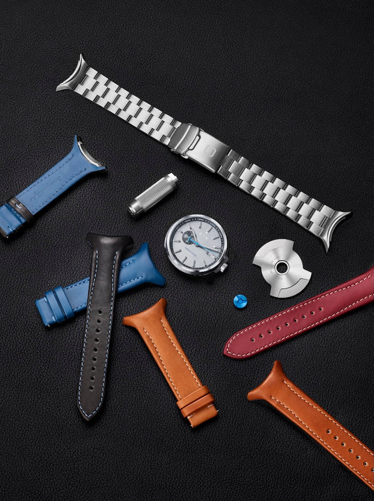 Collection of watch straps and watch parts on a dark surface