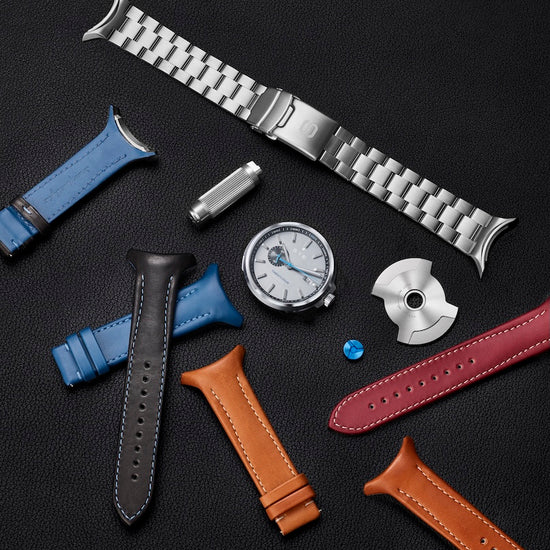 Collection of watch straps and watch parts on a dark surface